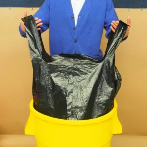 A man standing on top of a yellow trash can.