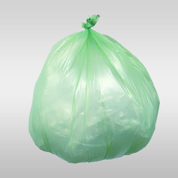 A green bag of garbage sitting on top of a white table.